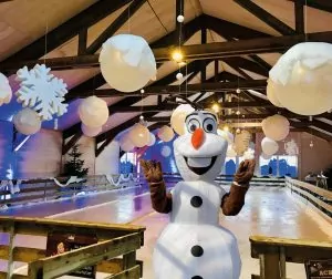 Das Schneemann-Maskottchen animiert zum Eislaufen auf der Eisbahn im Krewelshof EIFEL.