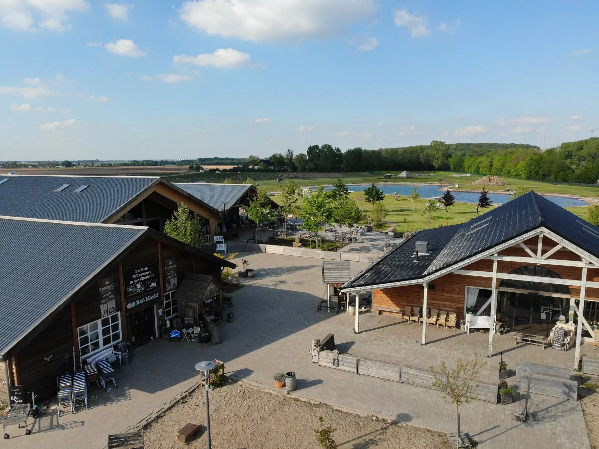 Der Krewelshof Eifel mit Hofgebäuden und Grünanlage aus der Vogelperspektive.
