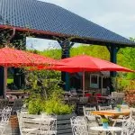 Hof-Restaurant mit roten Schirmen und vielen gemütlichen Sitzgelegenheiten.